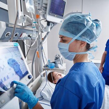 Hospital nurses checking on woman patient at intensive care unit