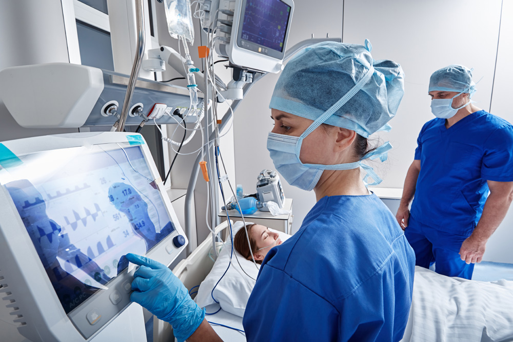 Hospital nurses checking on woman patient at intensive care unit