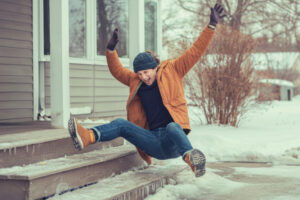 Person humorously slips on icy porch steps during a winter day