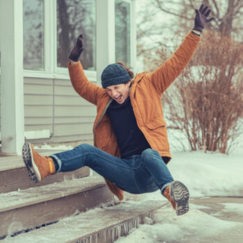 Person humorously slips on icy porch steps during a winter day